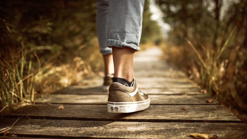 Feet walk on a wooden path
